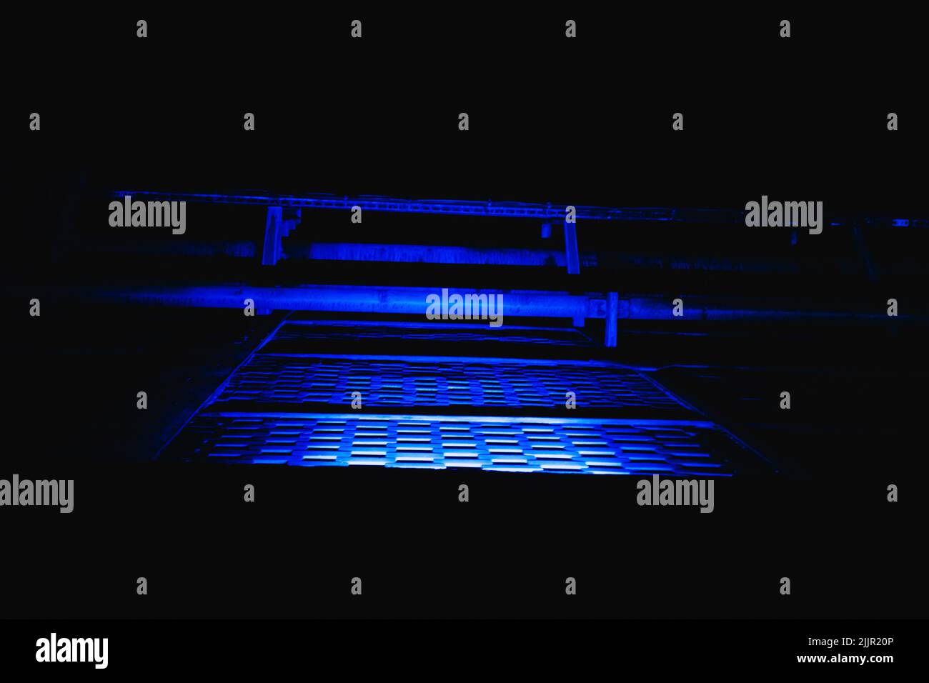 A blue trap door with old tubes at night Stock Photo Alamy