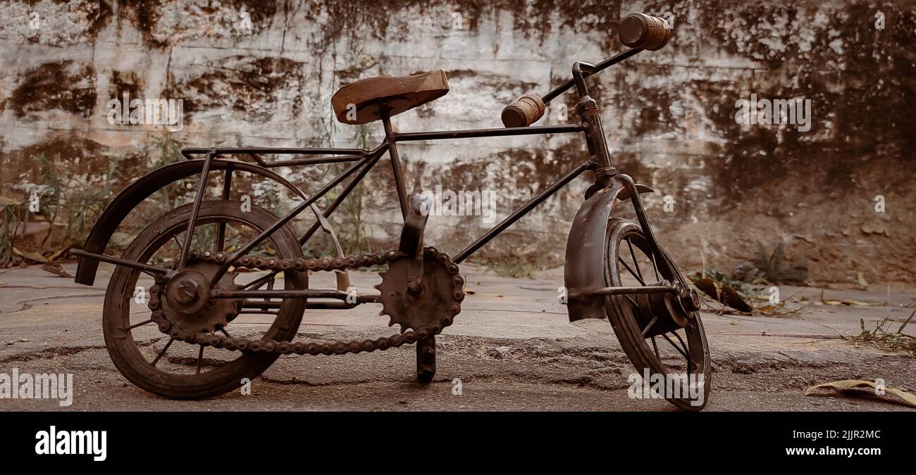 An old vintage bicycle parked on the asphalt ground Stock Photo