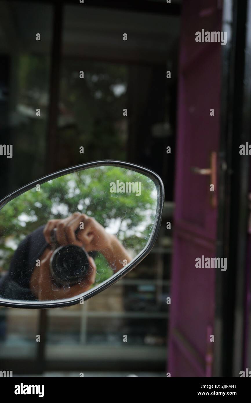 A closeup shot of a photographer doing selfie in auto mirror Stock Photo