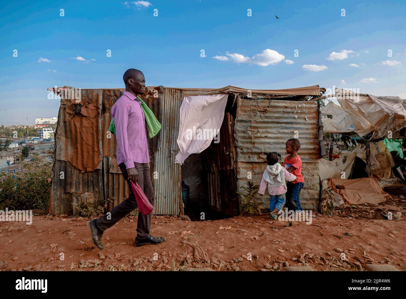Nairobi, Kenya. 16th Mar, 2022. A man walks past children playing by ...