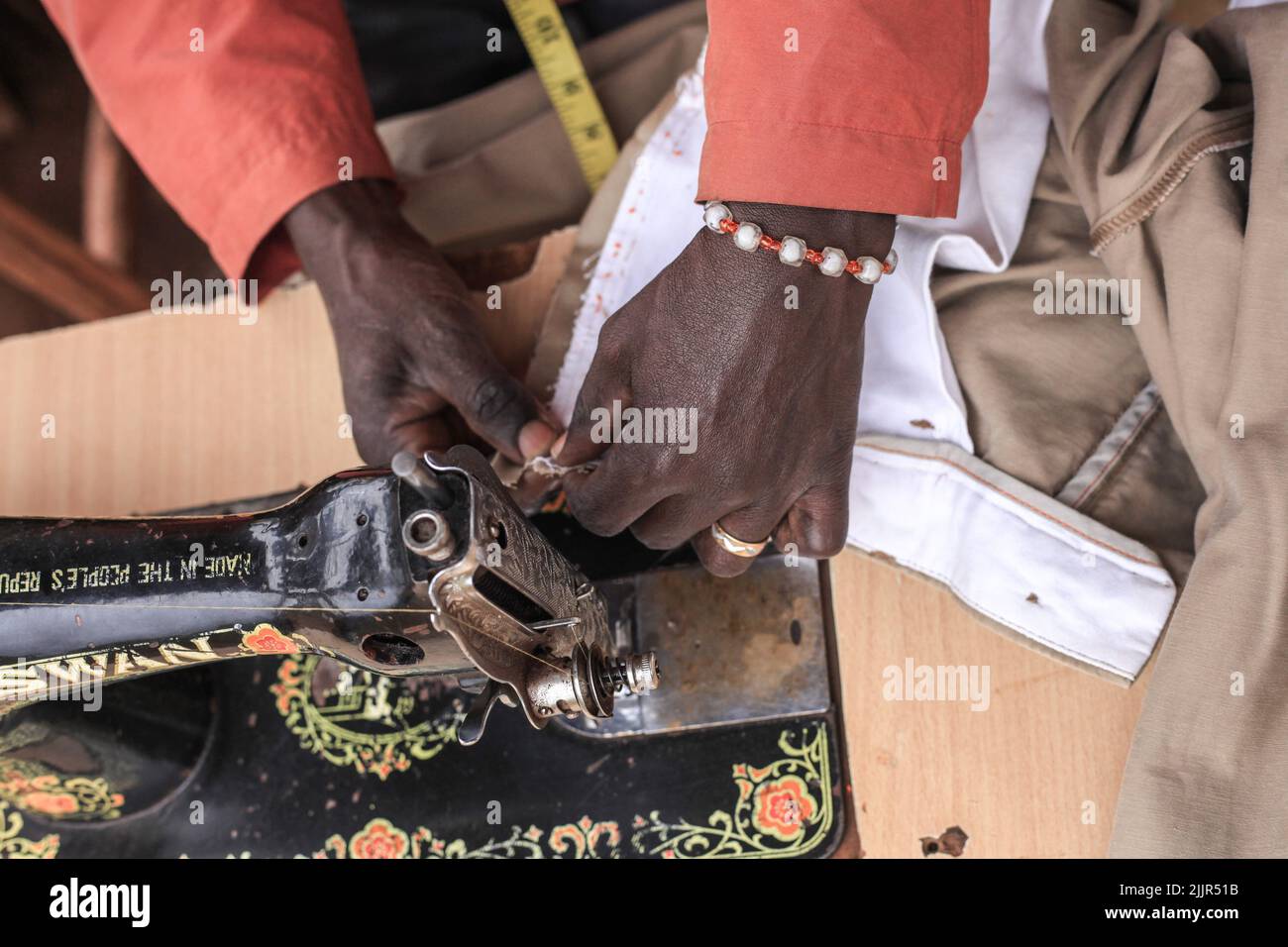 Nairobi, Kenya. 22nd July, 2022. A tailor repairing clothes in Kibera