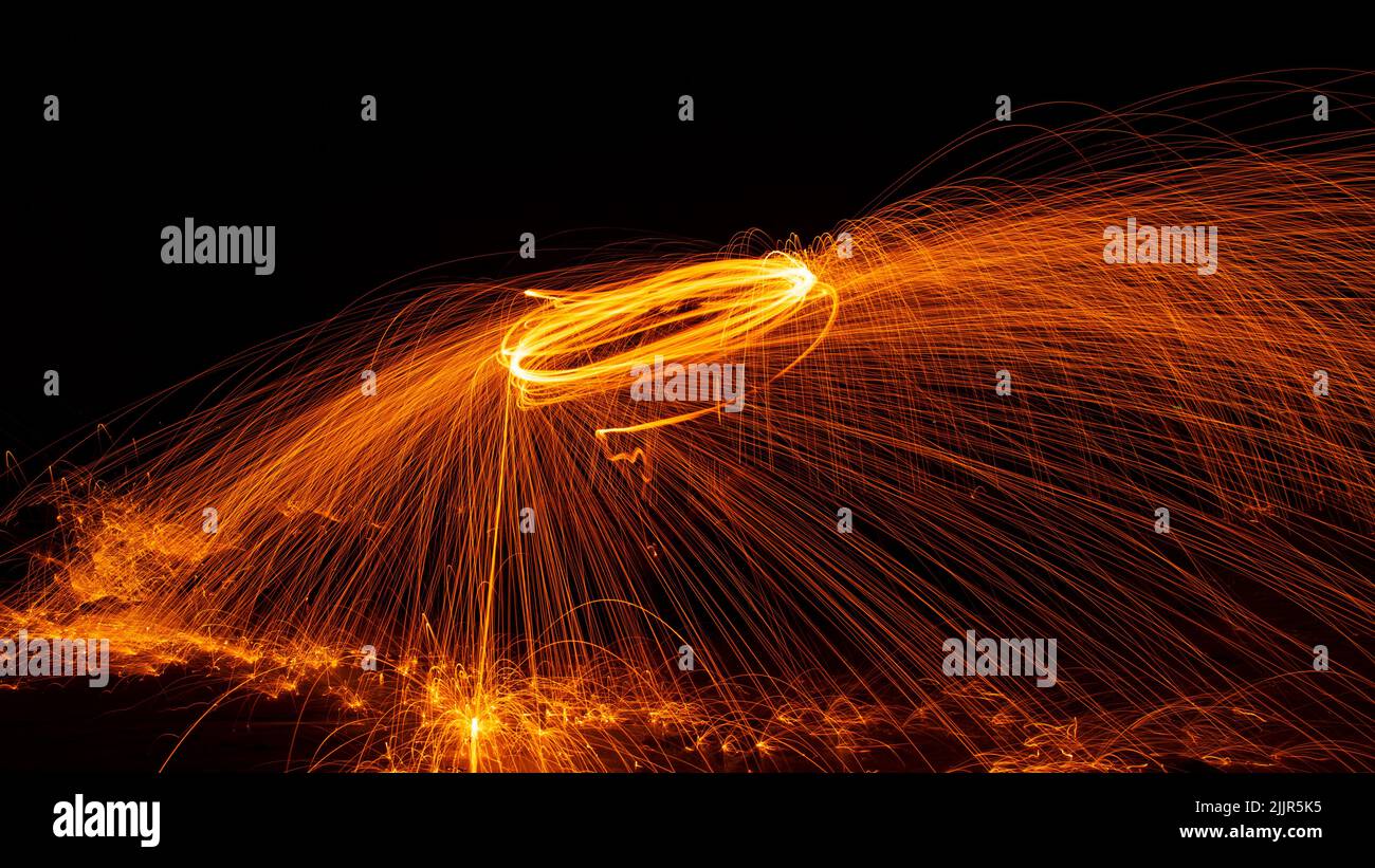 Swing fire Swirl steel wool light photography with reflex in the water long exposure speed
