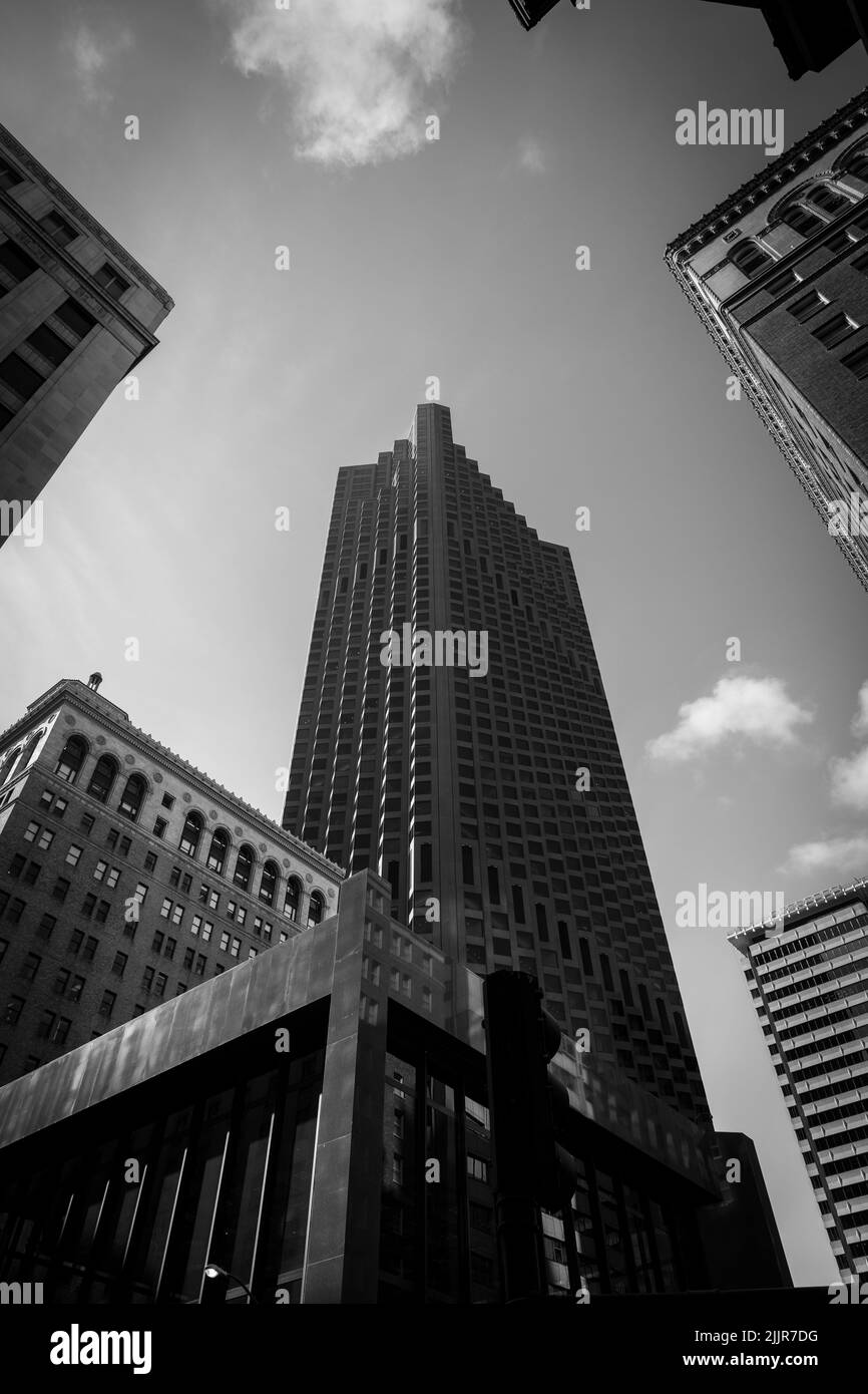 a Low angle grayscale shot of high rise buildings under a cloudy sky ...