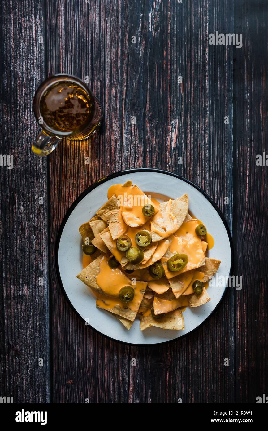Mexican nachos chips with american cheese, beer and jalapeños in Mexico