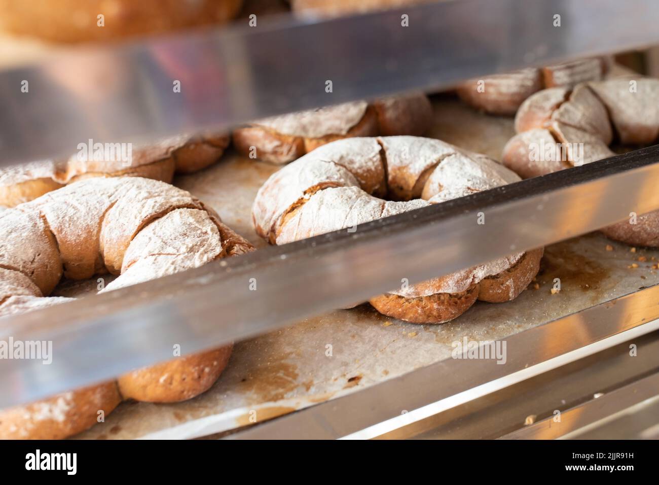 Finished French bread in the bakery on the racks. Rustic bread, crown of kings Bordeaux. Front