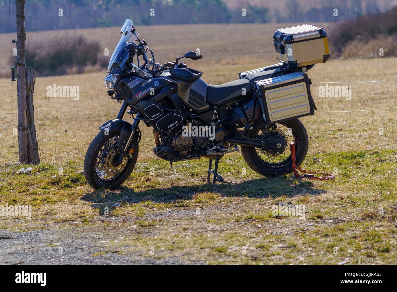 A parked Yamaha XT 1200 Z motorcycle with side cases on the edge of the meadow Stock Photo