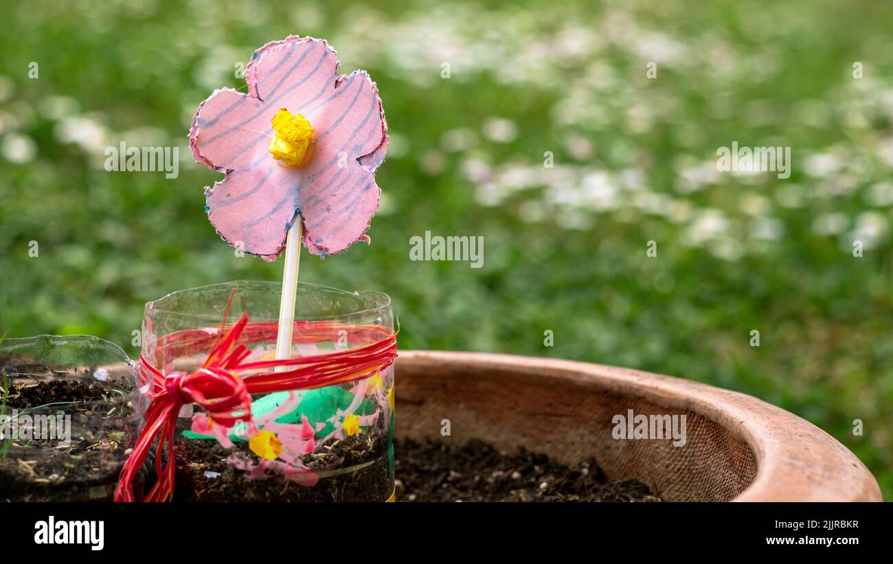A closeup shot of a pink artificial flower in a pot Stock Photo