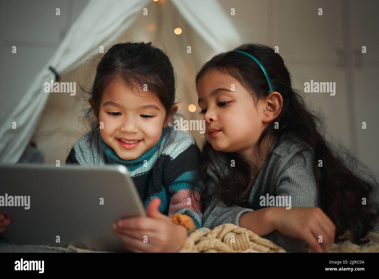 Sister quality time. two sisters using a digital tablet at home Stock ...