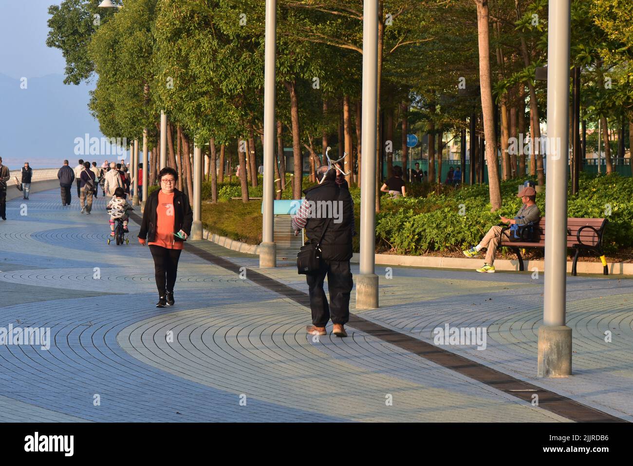 The people walking along the embankment in the evening at sunset in Hong Kong Stock Photo
