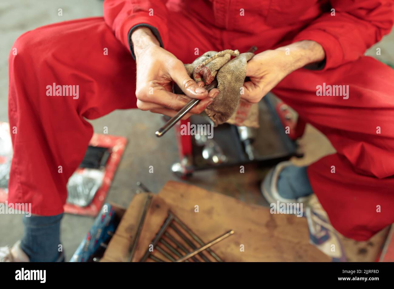 A closeup shot of a mechanic cleaning his tools to mount the car engine