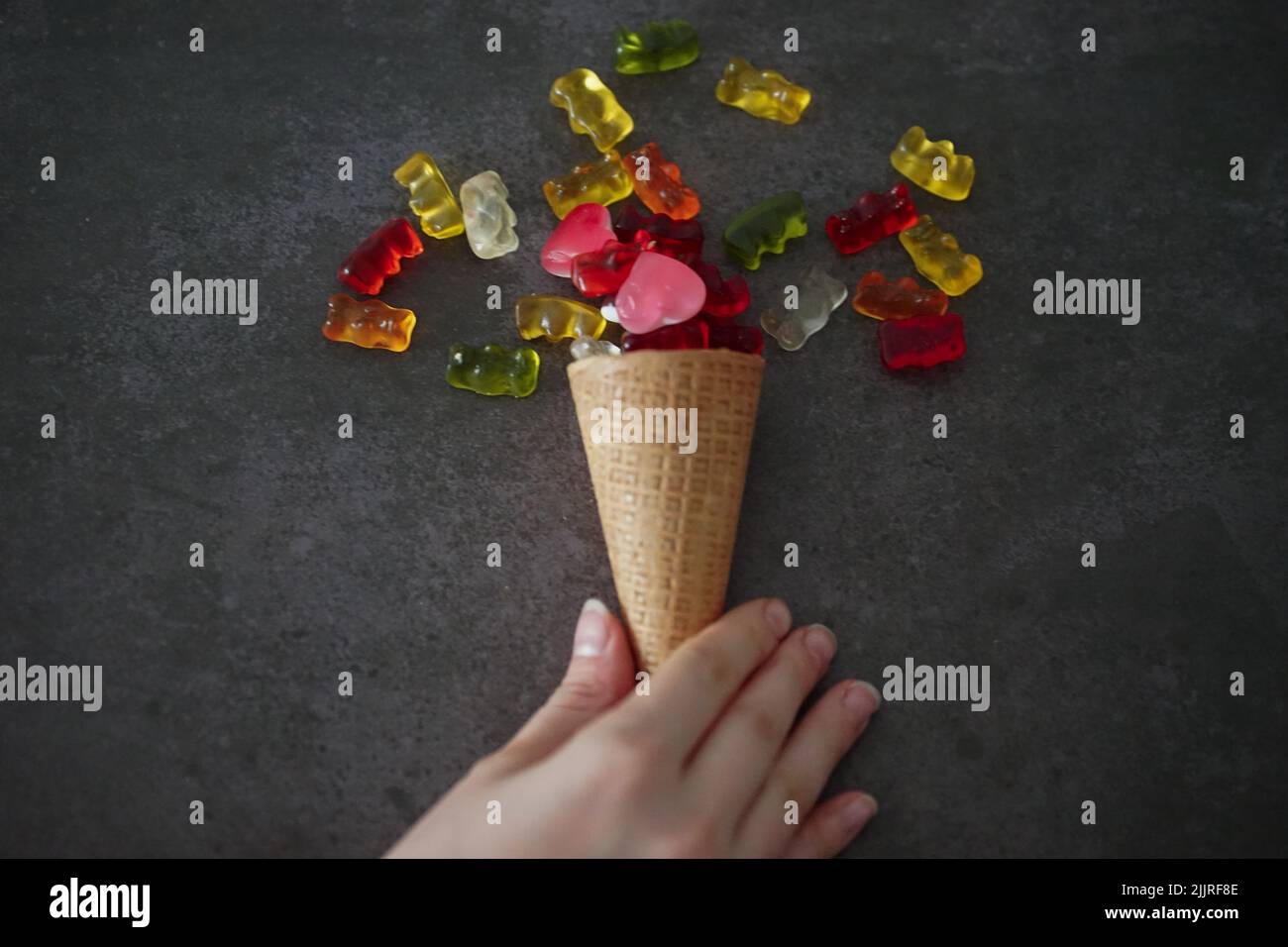 A closeup shot of an ice cream cone with gummy bears and heart jellies Stock Photo