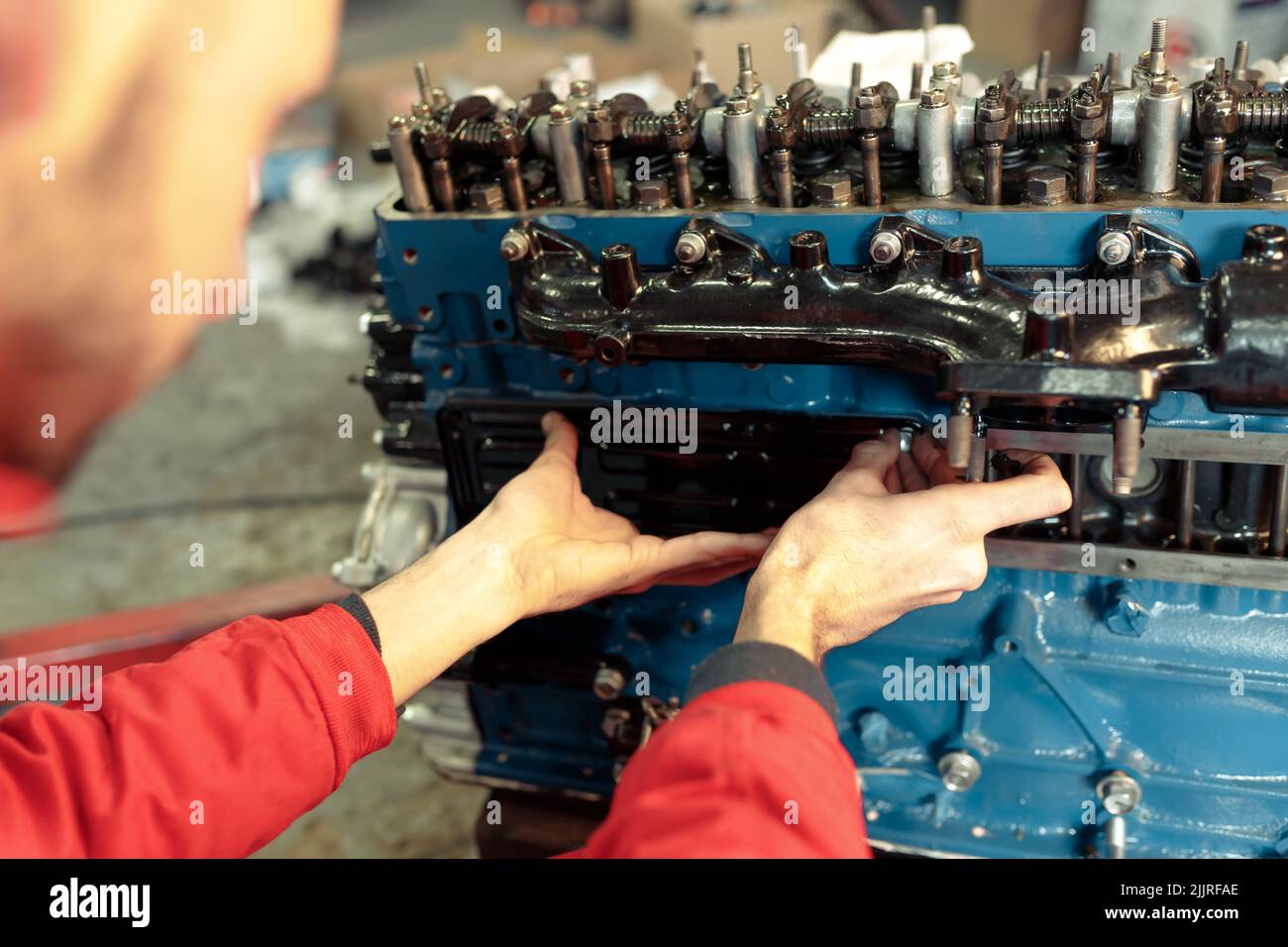 A closeup of a mechanic mounting the car engine Stock Photo