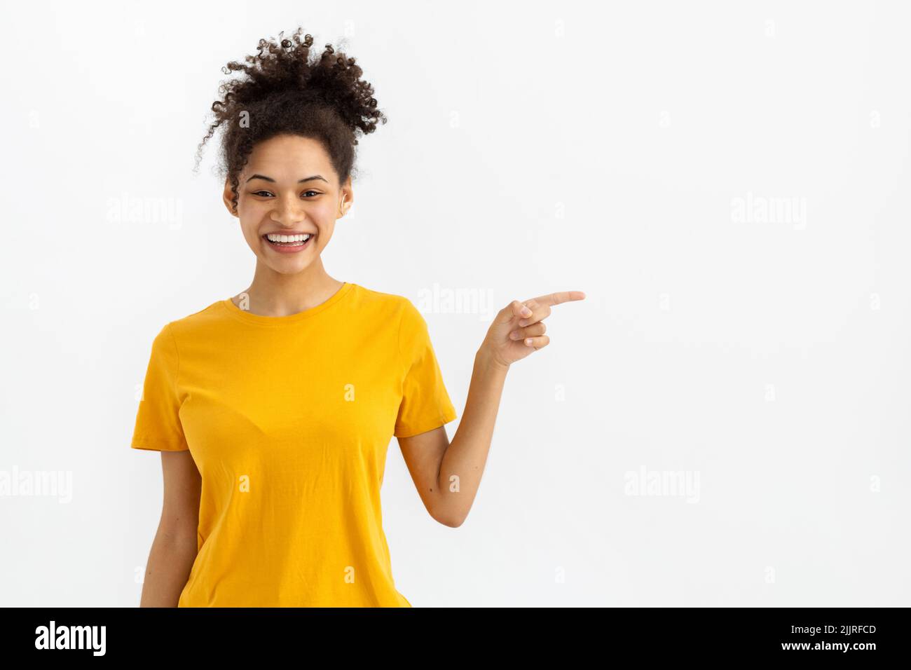 Happy woman smiling with his finger pointing on white background with copy space Stock Photo