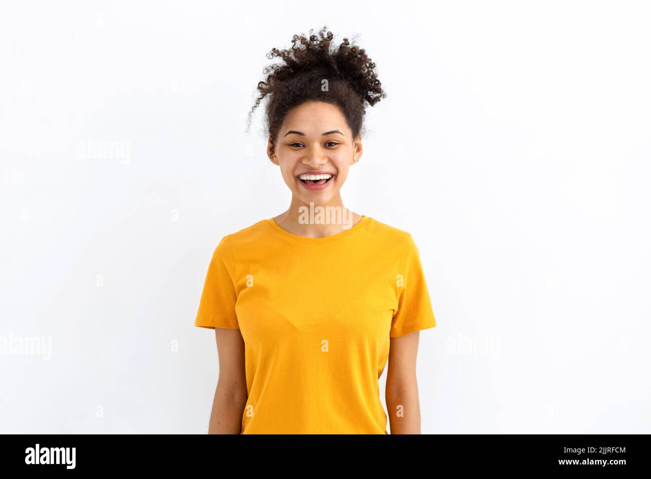 Portrait young funny positive smiling woman dressed in yellow t shirt on white background good mood concept Stock Photo