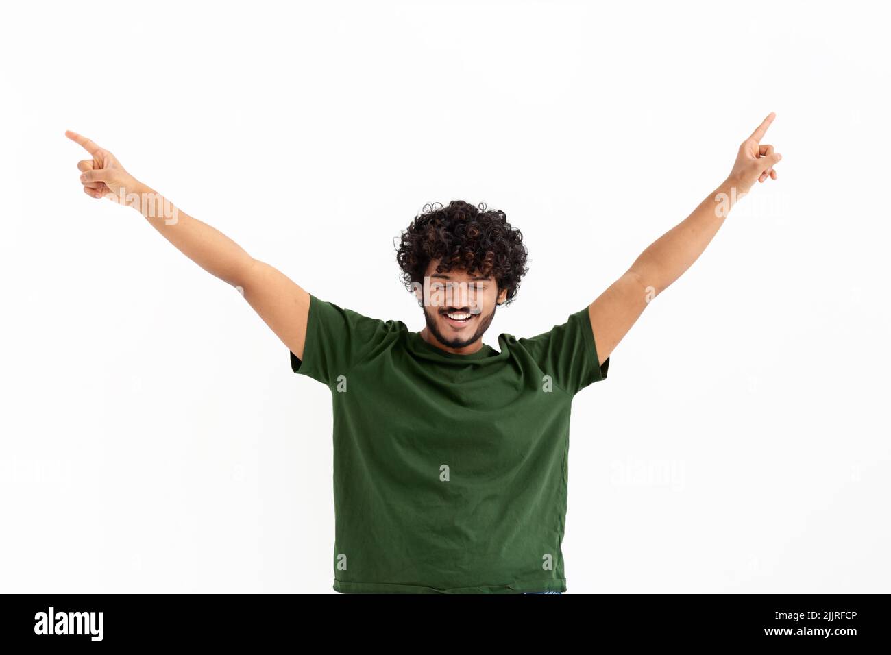 Portrait of happy young Asian man with curly hair celebrating victory raised his hands up on white background Stock Photo