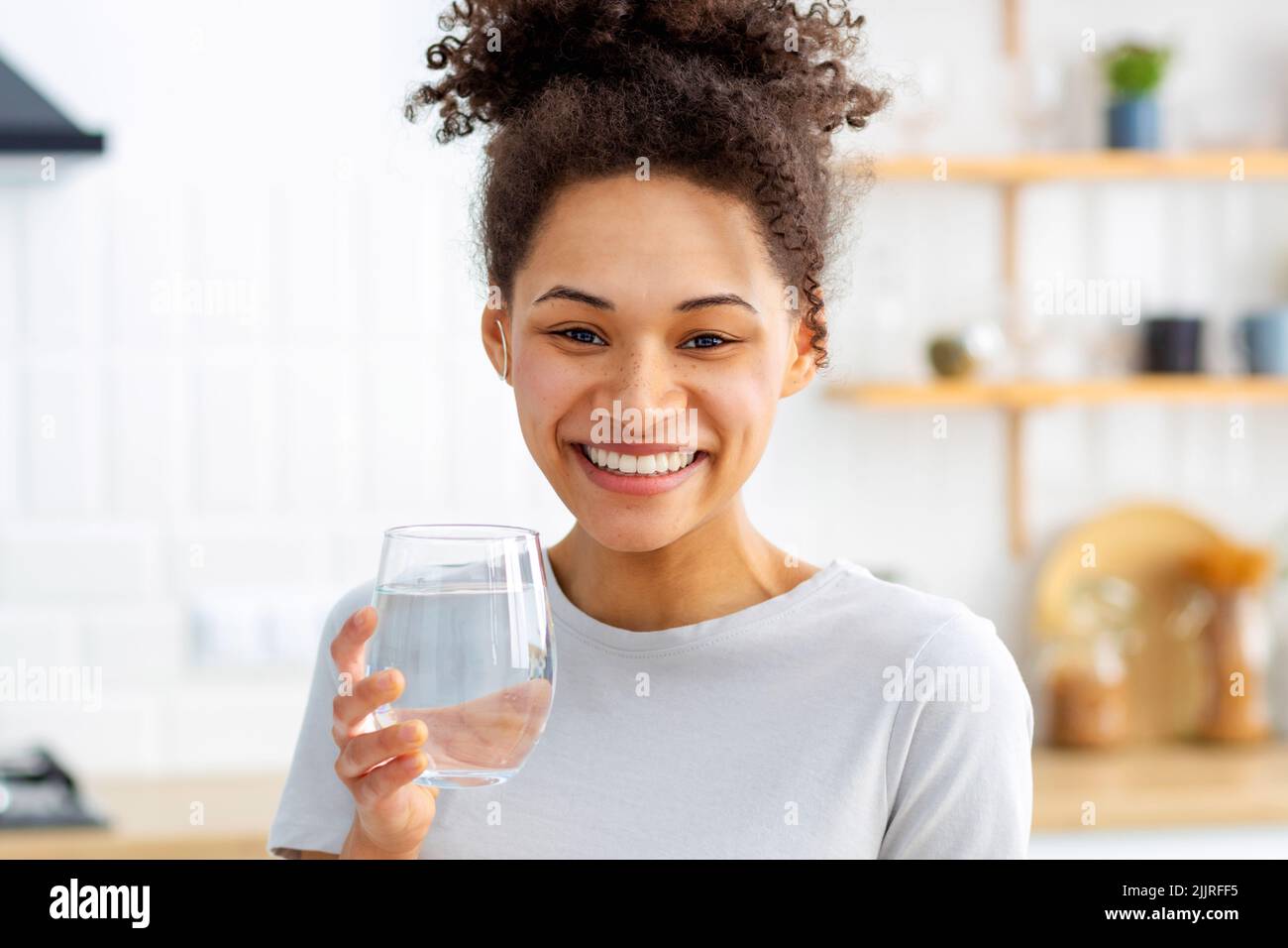Healthy lifestyle concept. Beautiful young woman holding a glass of clean fresh water Stock Photo