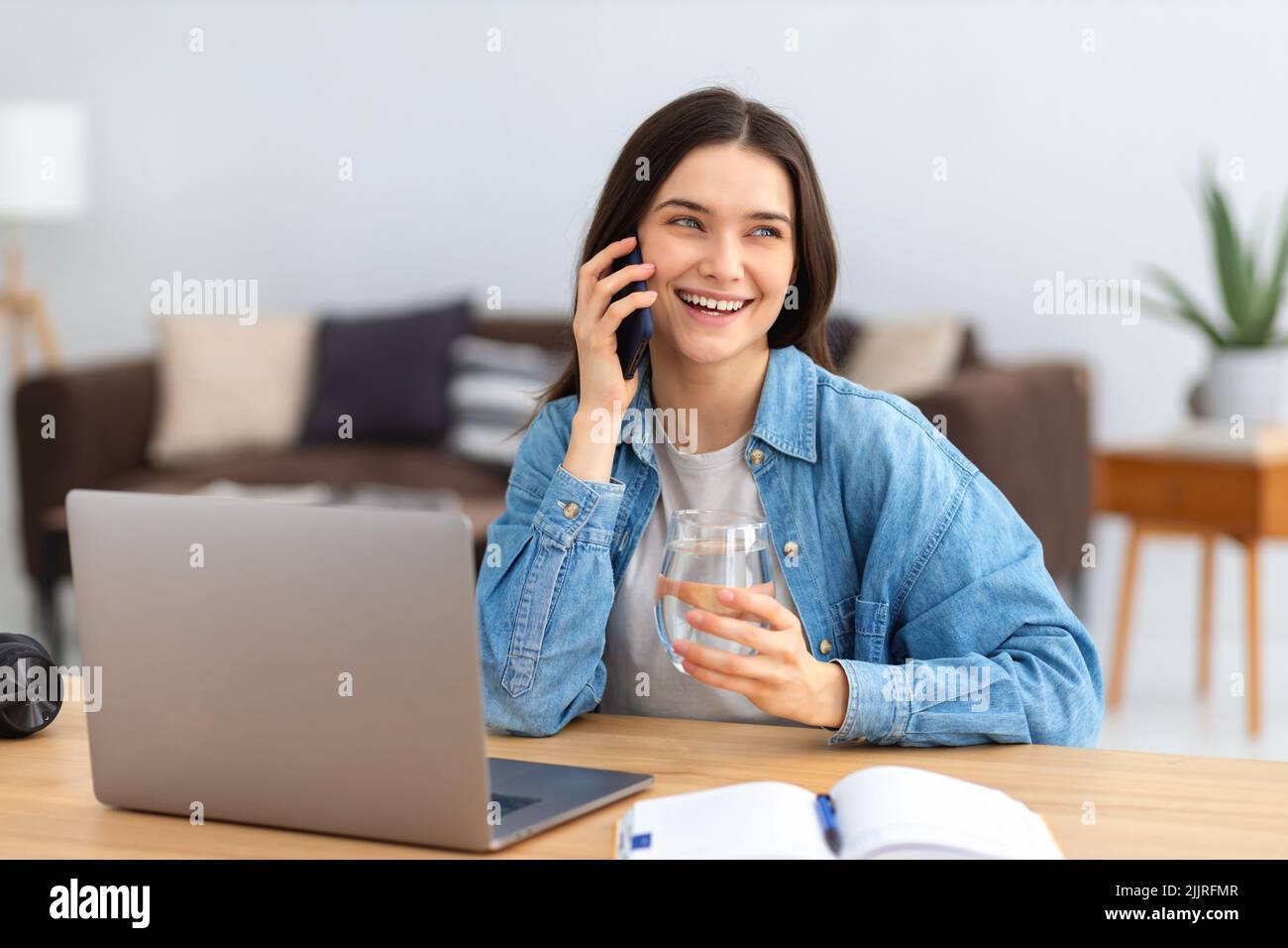 businesswoman or freelancer talking on mobile phone sitting in home office. Successful female entrepreneur working Stock Photo