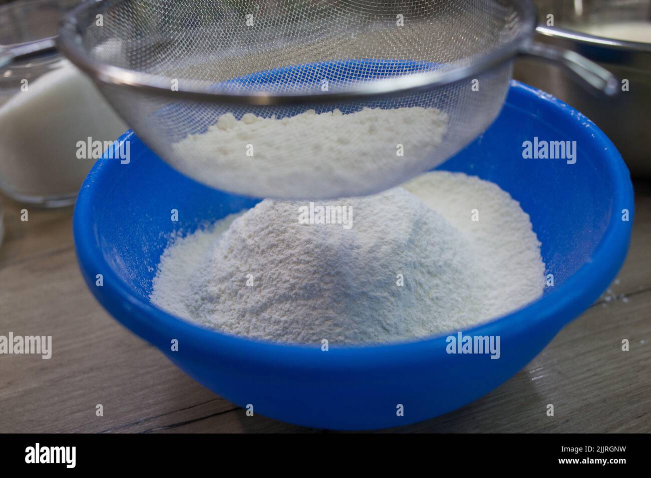 Sifting white flour through a sieve Stock Photo Alamy