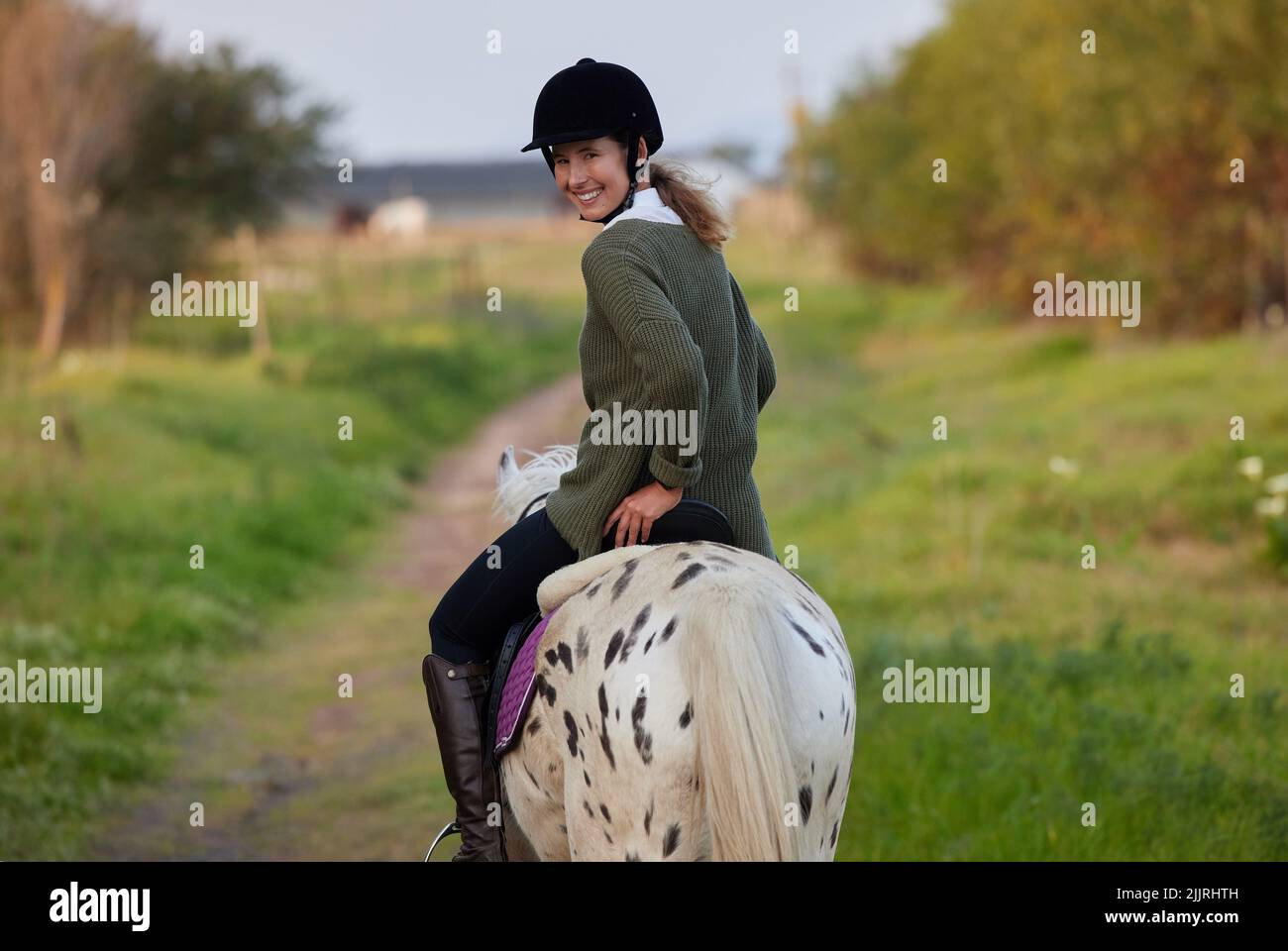 The essential joy of being with horses. a young woman riding her horses outside on a field. Stock Photo
