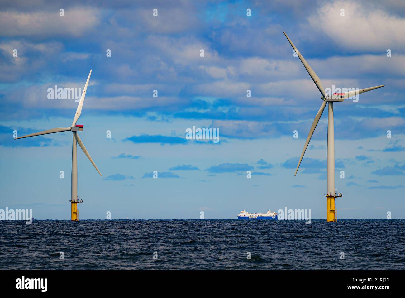A ship passes wind turbines at RWE's Gwynt y Mor, the world's 2nd largest offshore wind farm located eight miles offshore in Liverpool Bay, off the coast of North Wales. Picture date: Tuesday July 26, 2022. Stock Photo