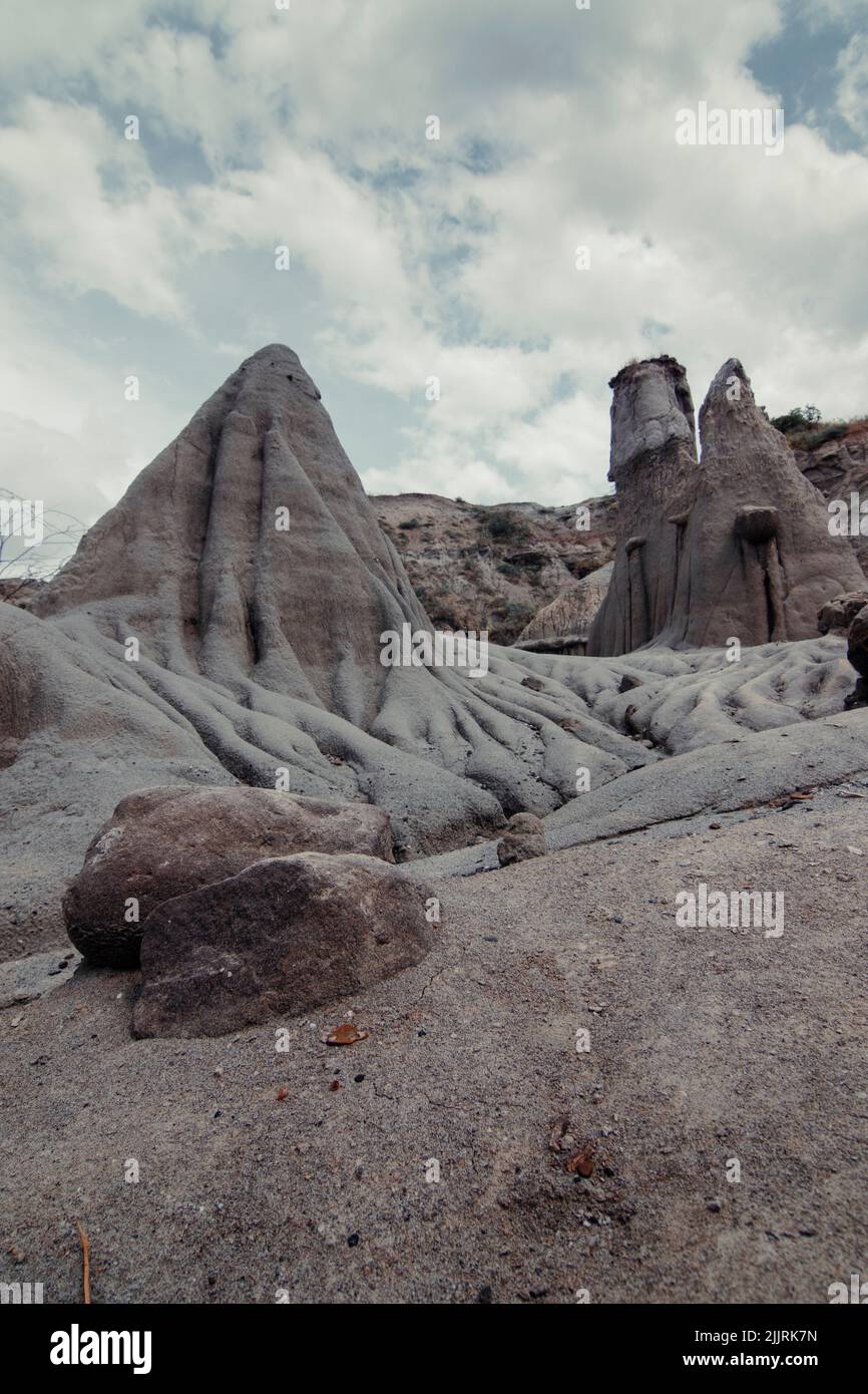 A vertical shot of sandy rock formations in Cappadocia under blue bright sky Stock Photo