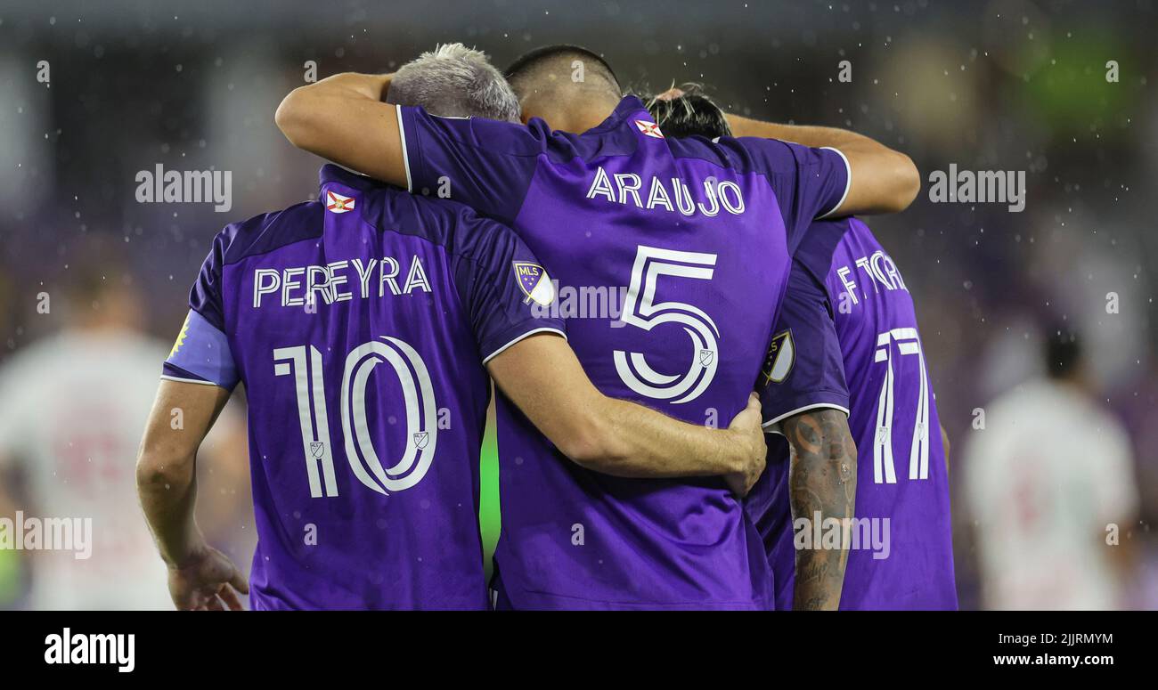 Orlando, FL:  Orlando City midfielders Mauricio Pereyra (10) and César Araújo (5) forward Facundo Torres (17) group hug after a goal during the Lamar Stock Photo
