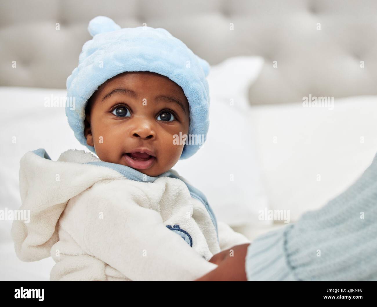 Did you just call me cute. an adorable baby boy sitting on a bed Stock