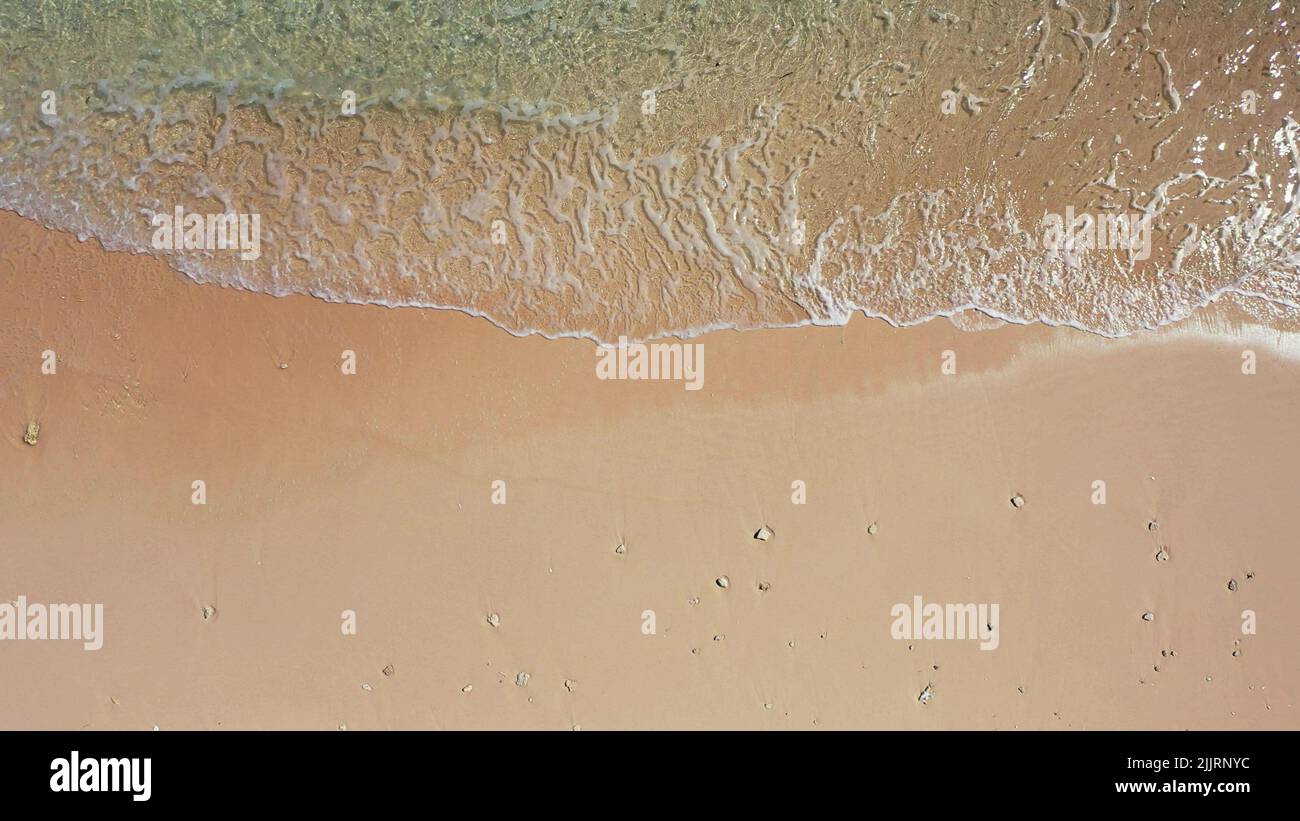 An aerial view of soft ocean waves with foam on a sandy beach Stock ...