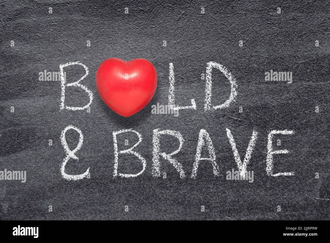 bold and brave phrase written on chalkboard with red heart symbol Stock Photo