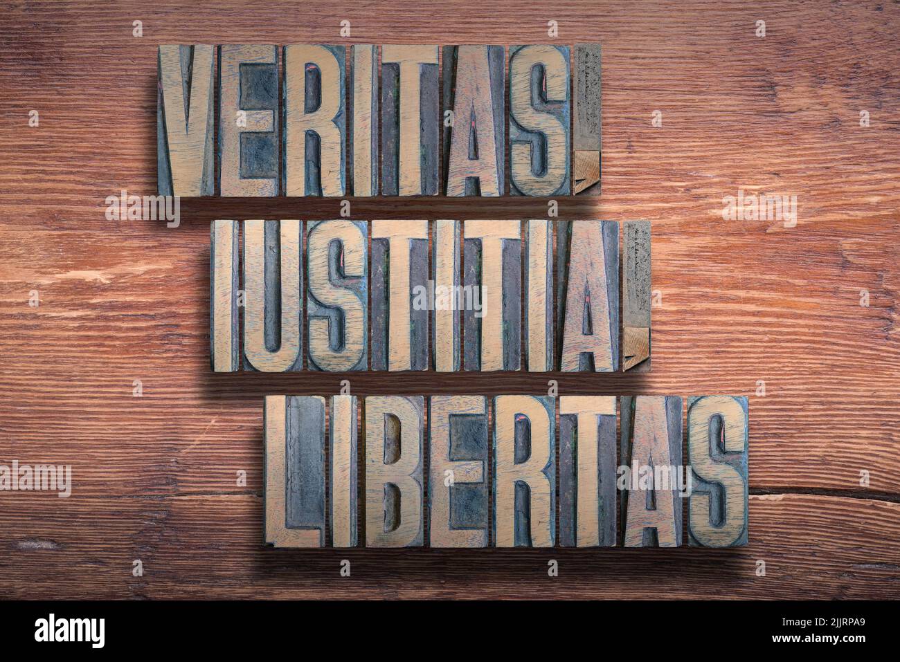 veritas, iustitia, libertas ancient Latin saying meaning - truth, justice, liberty, combined on vintage varnished wooden surface Stock Photo