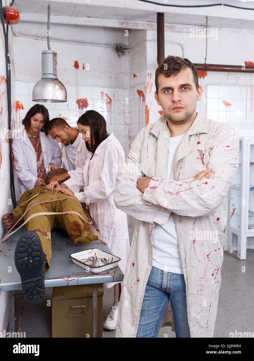 Focused guy in escape room with traces of blood Stock Photo