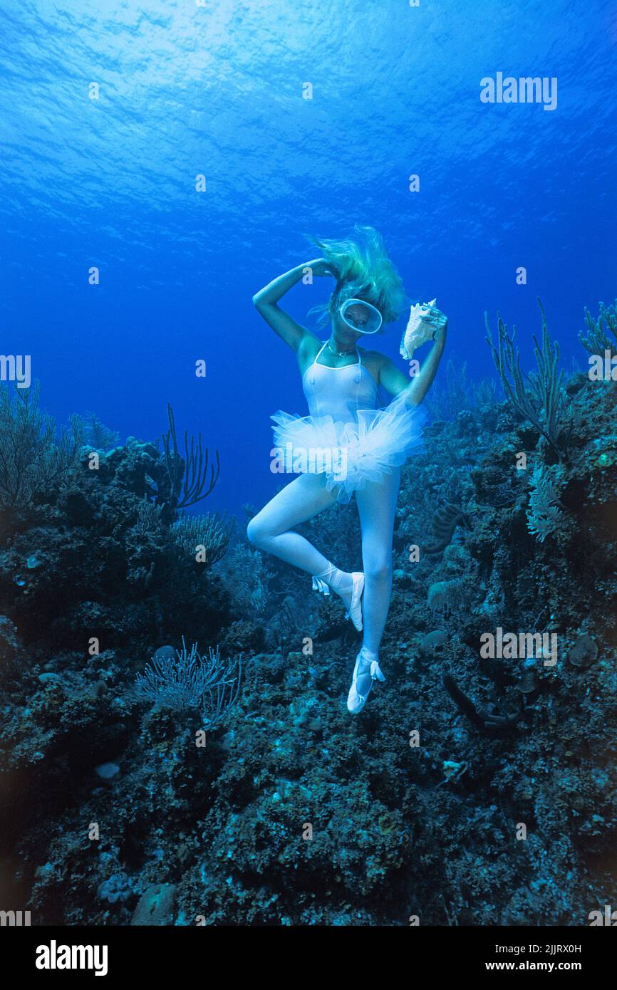 Model photography, ballett dancer (woman) posing with a sea shell in a caribbean coral reef, Isla de Juventud, Cuba, Caribbean Stock Photo