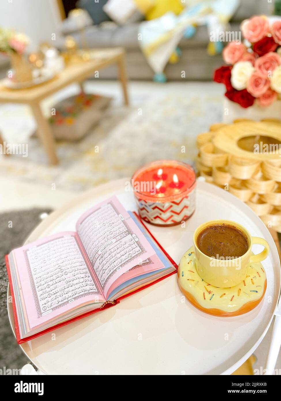 A top view of beautifully arranged cups of coffee on a tablecloth decorated with flowers and a journal Stock Photo