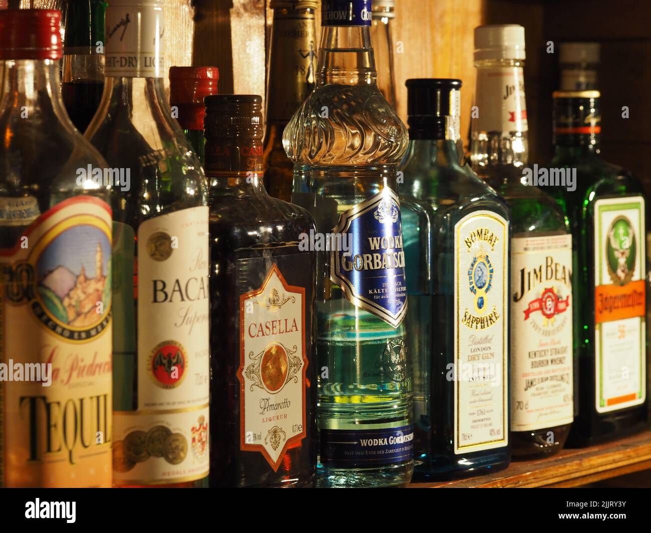 Some Liquor bottles at a bar including Vodka Gorbatschow, Jim Beam, Bombay Sapphire, Bacardi, Esella, Jaegermeister, Tequila Stock Photo