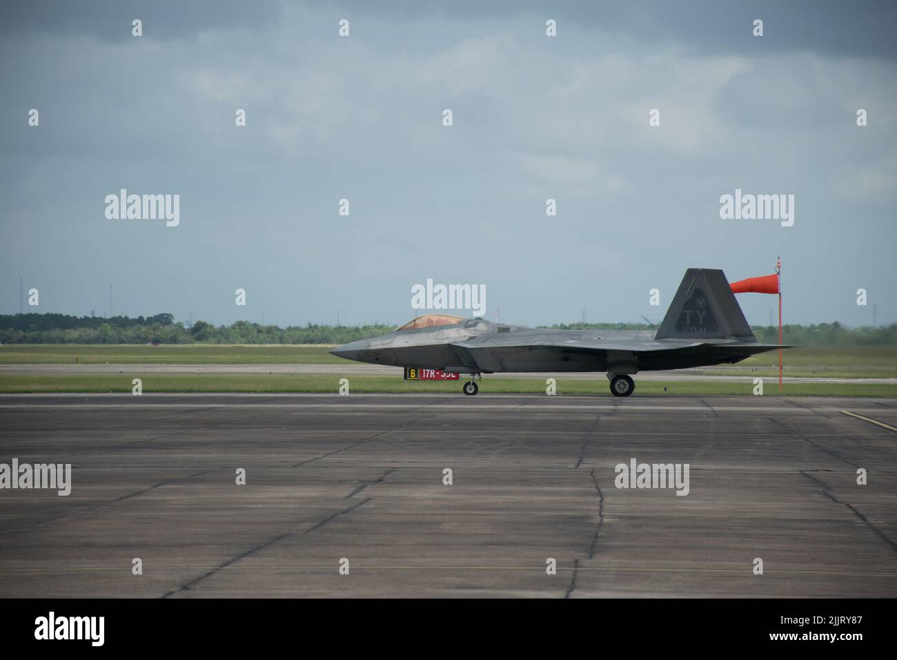 A F22 Raptor aircraft on a runway under a gray cloudy sky in Houston Stock Photo