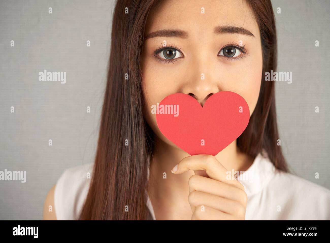 Head and shoulders portrait of attractive Asian woman looking at camera