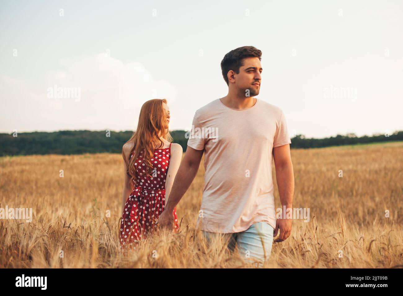 Shot of young caucasian man walking with his girlfriend on white field
