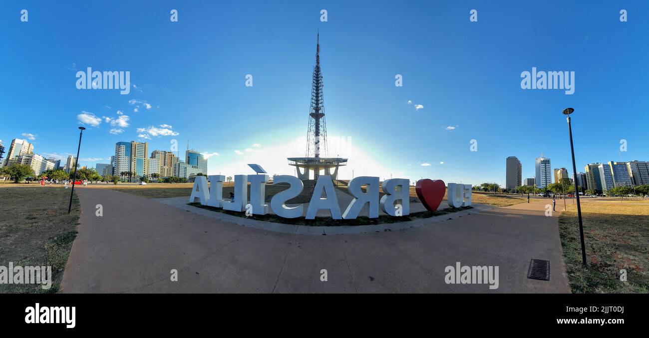A panoramic shot of a sign written Eu love Brasilia in the background of the television tower in downtown Brasilia Stock Photo