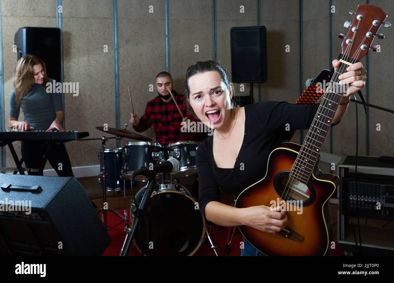 excited girl rock singer with guitar during rehearsal Stock Photo