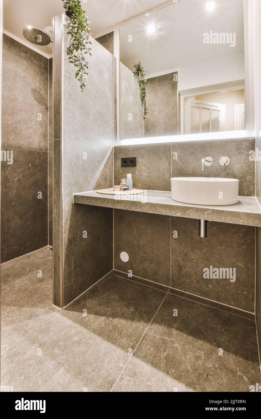 Sinks with mirrors and shower box with glass door in modern bathroom