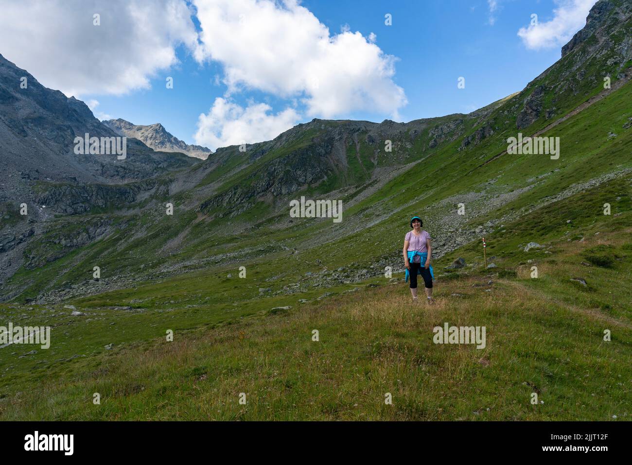Wanderin auf den steinigen Fussweg zum Gipfel. Frau auf Wanderwegen Gargellen, Montafon, Österreich. steiniger schmaler Weg am steilen Abhang Stock Photo