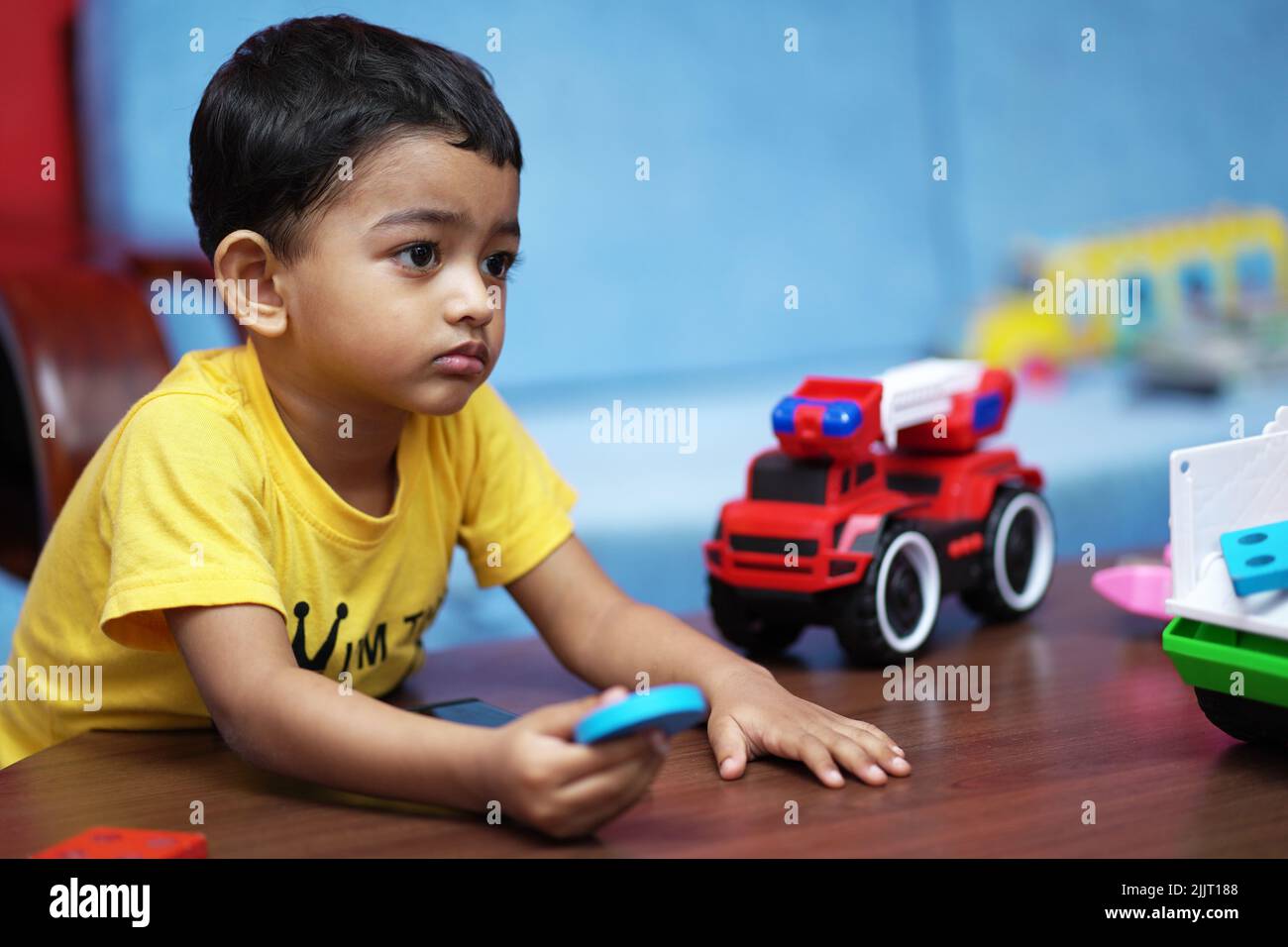 A beautiful shot of an Indian little kid playing with his toys Stock Photo