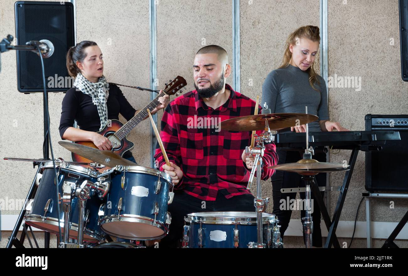 Rehearsal of music group with male drummer Stock Photo