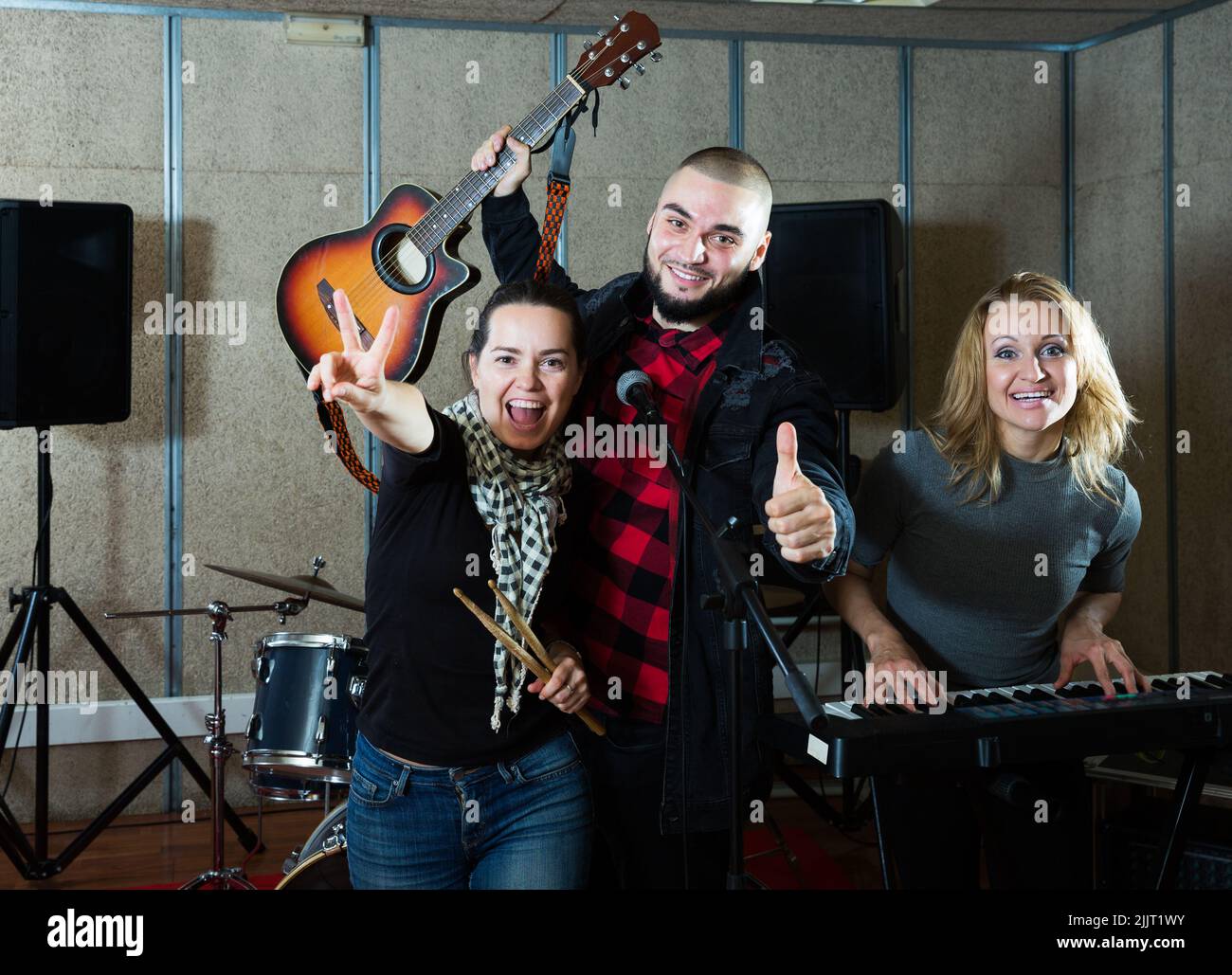 expressive group of rock musicians posing with instruments Stock Photo