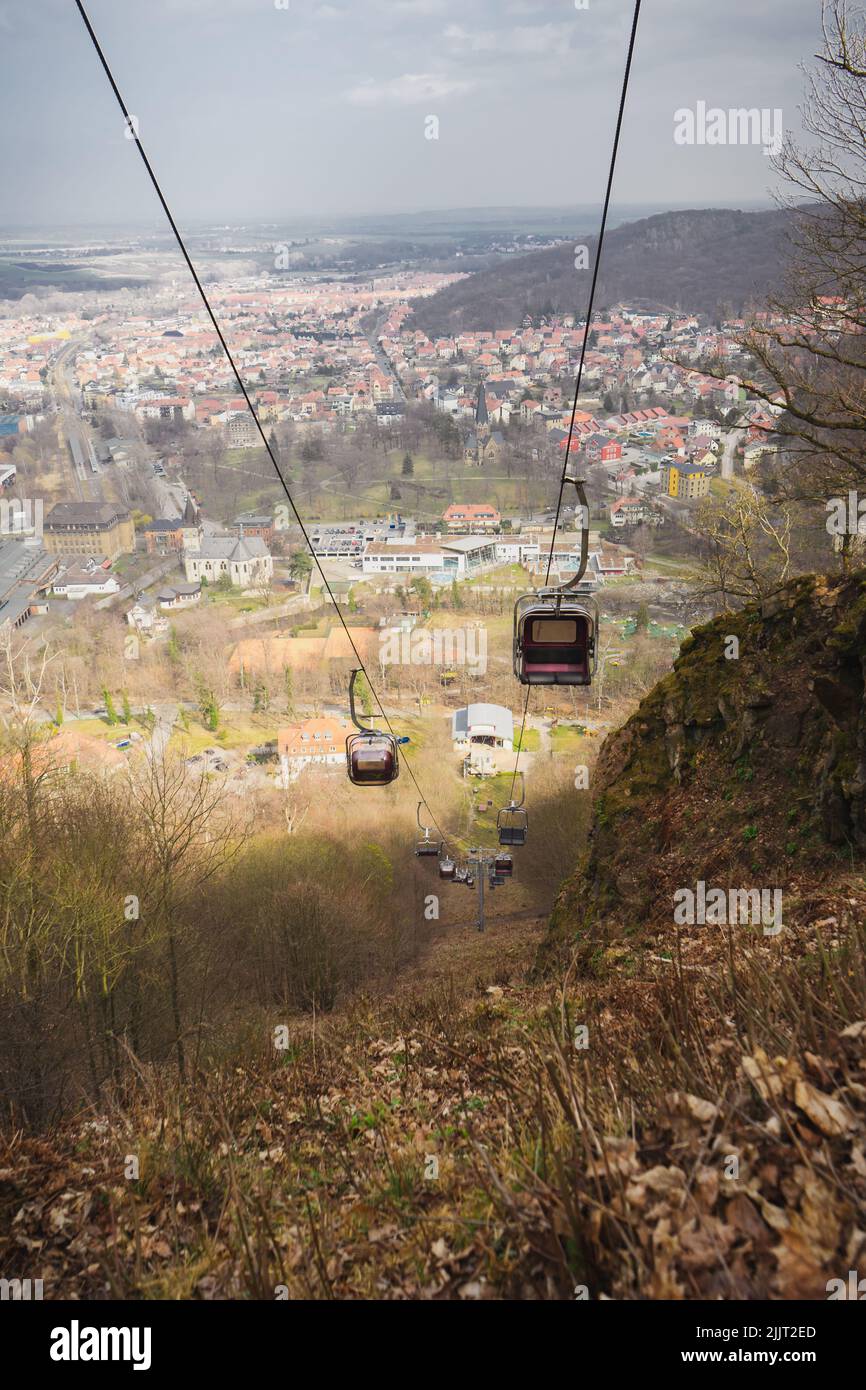 A vertical shot of a cable car ropeway from above overlooking the city below Stock Photo