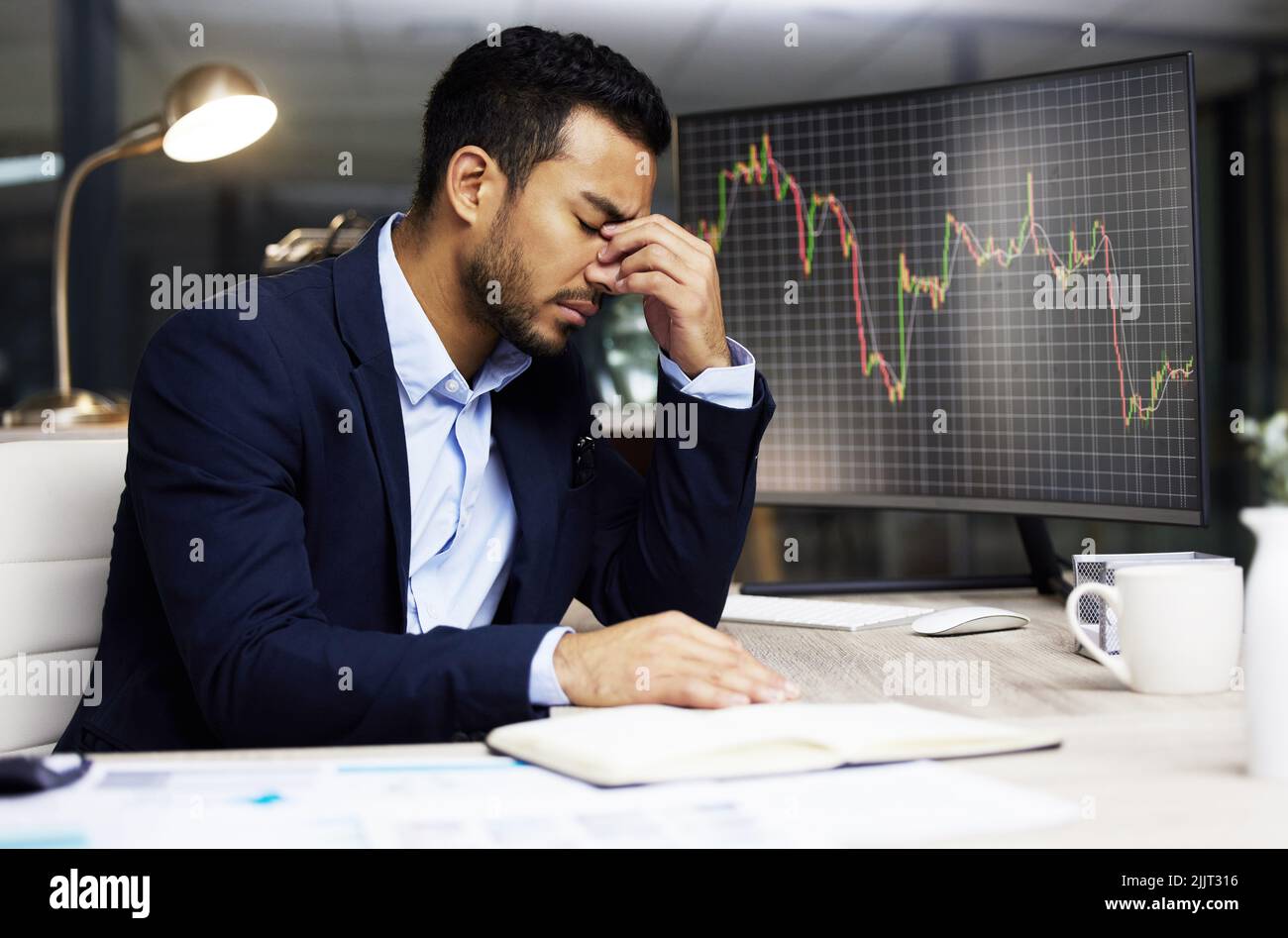 Businessman with depression analysing the stock market and trading during a financial crisis. Stressed trader in a bear market, looking at stocks Stock Photo