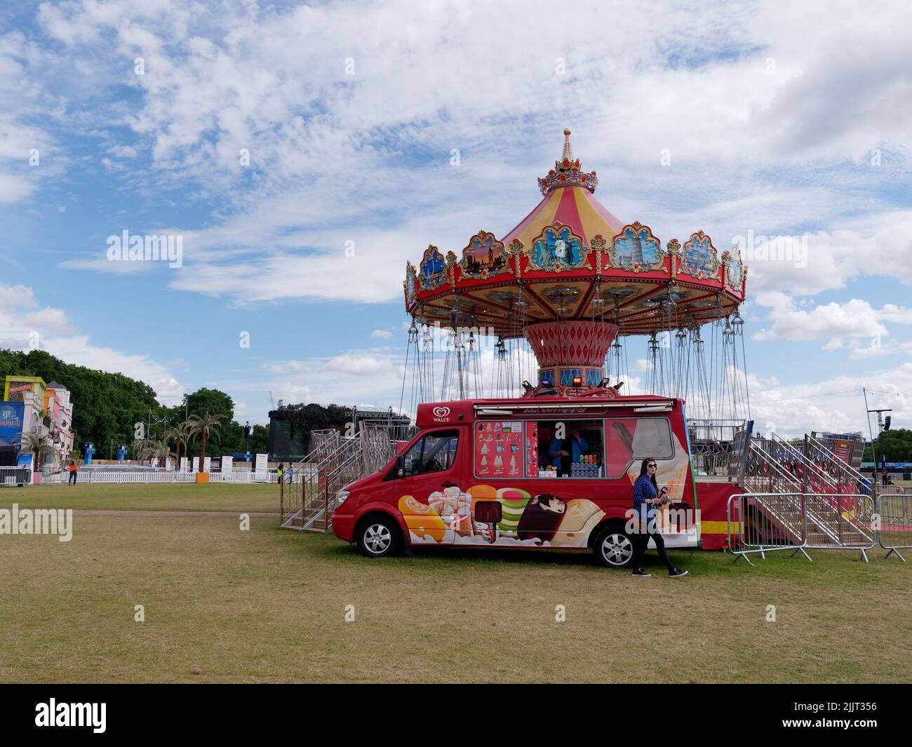 London, Greater London, England, June 30 2022: Ice Cream van and Fairground swing ride aka chair swing ride inside BST Byde Park concert arena Stock Photo