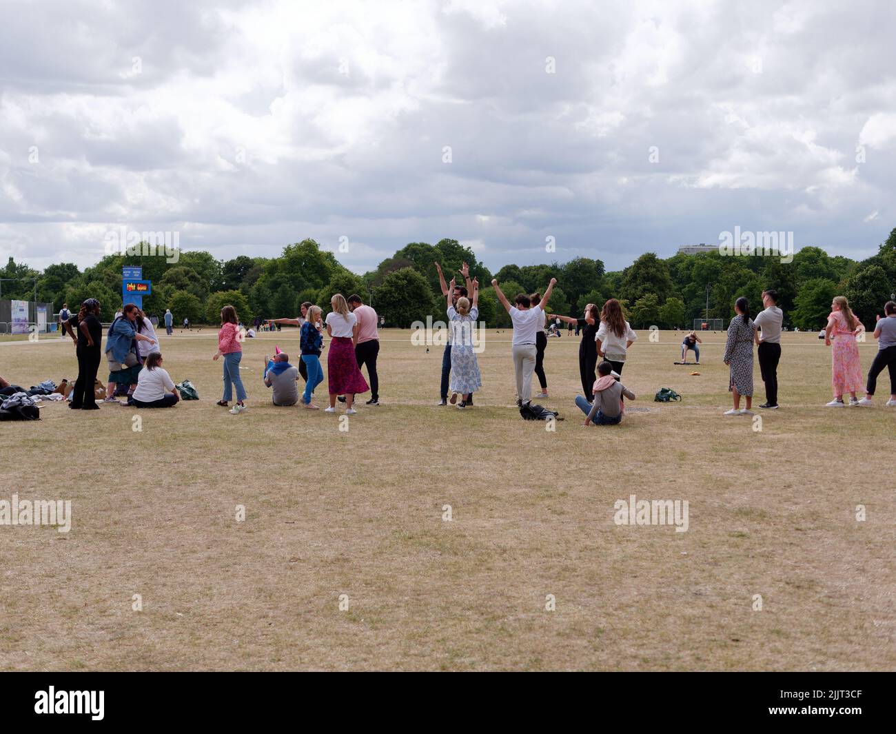 London, Greater London, England, June 30 2022: Friends having fun and in Hyde Park with hands in the air Stock Photo