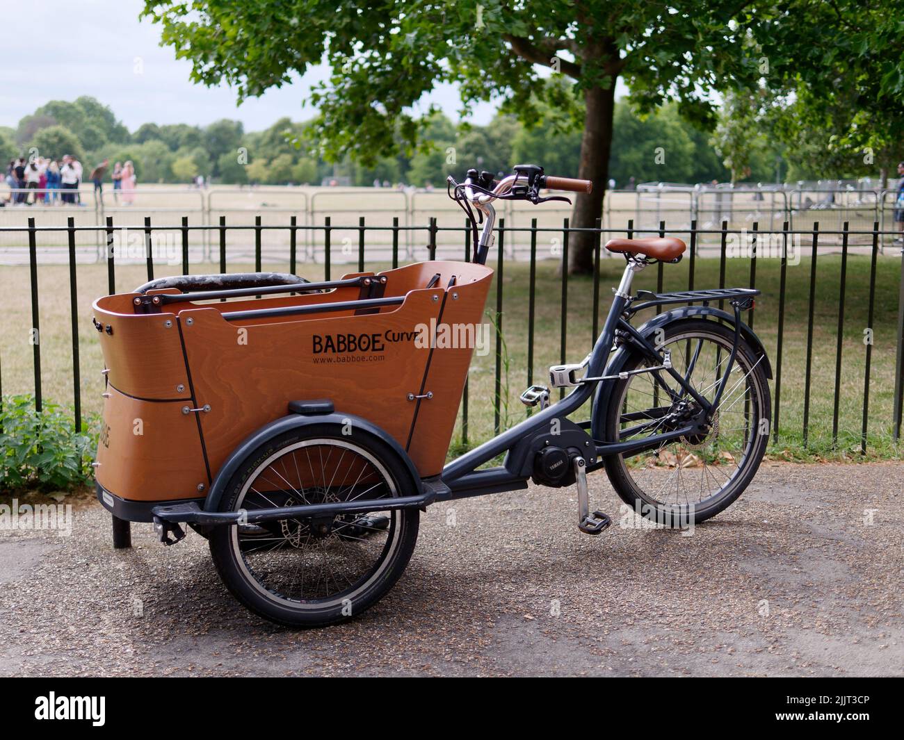 London, Greater London, England, June 30 2022: Electric Babboe Curve three wheel cargo bike with wooden storage or seating area at the front. Hyde Par Stock Photo