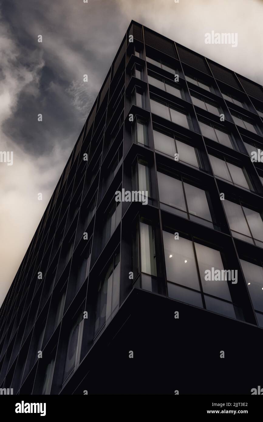 A low-angle shot of a modern office building with sharp edges under the cloudy sky in Ireland Stock Photo